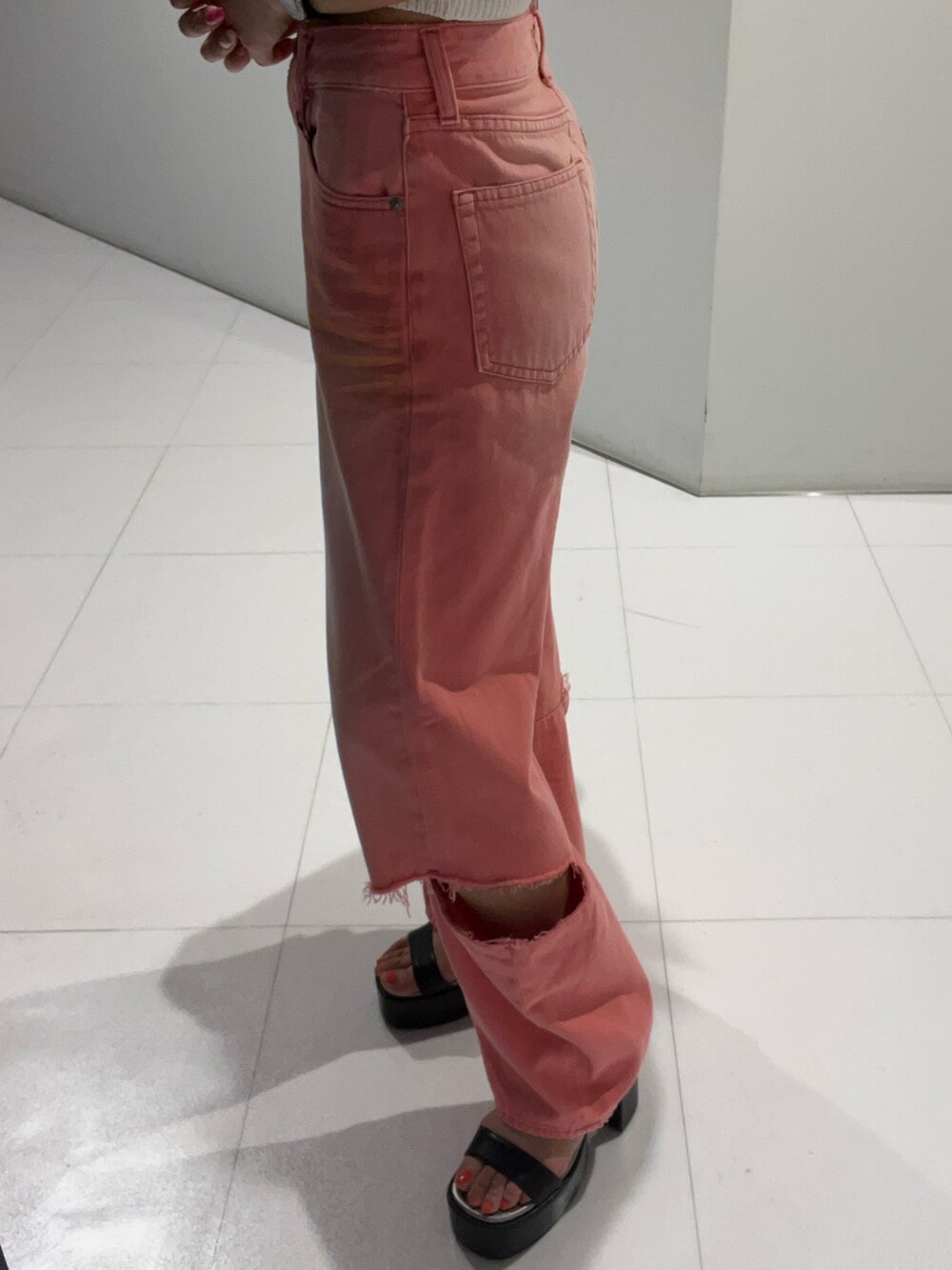 ブラック系のタンクトップ、ピンク系のデニムパンツ、ブラック系のサンダルを着用したレディースの夏コーディネートの4枚目の写真