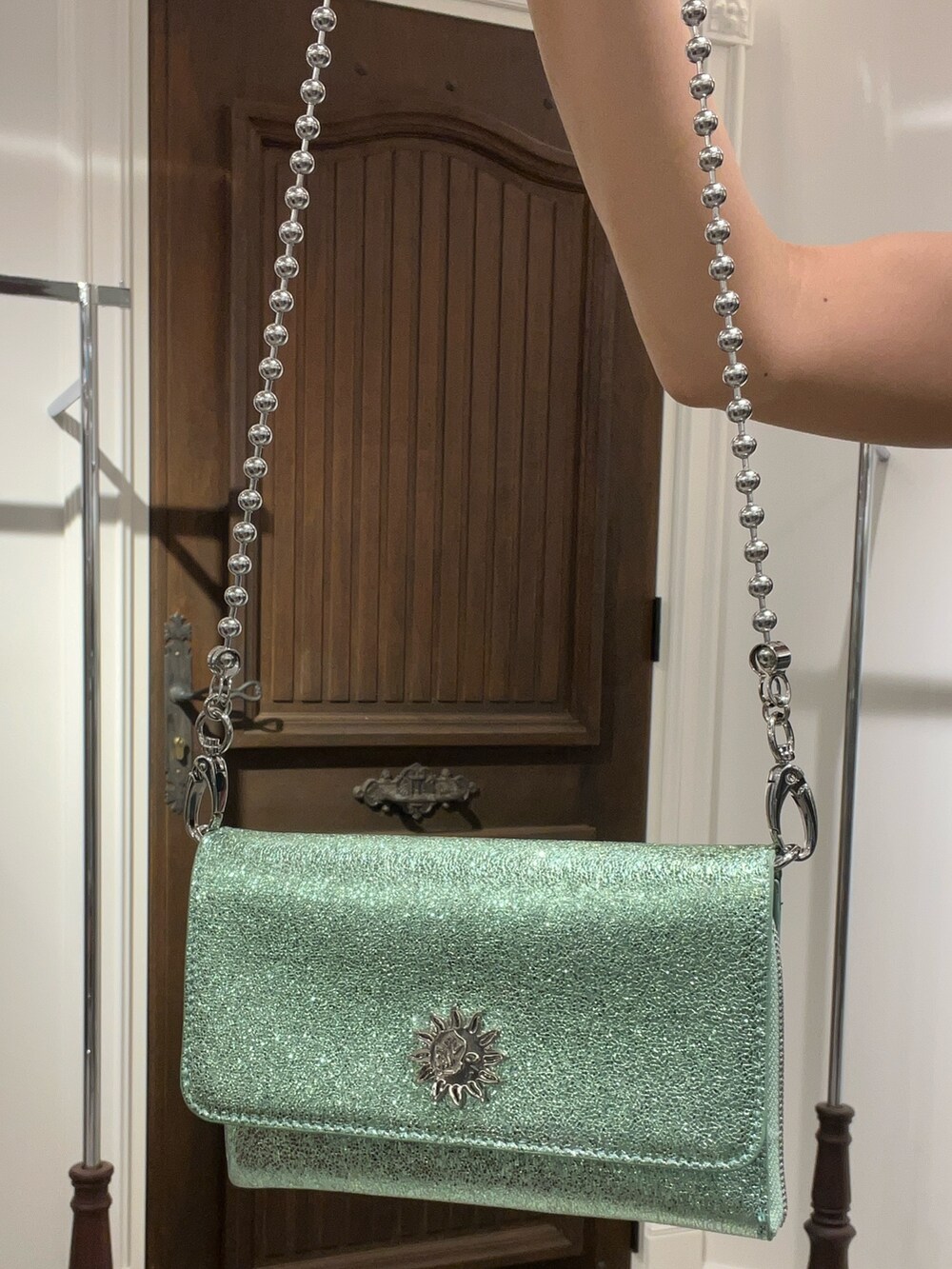 ブラック系のタンクトップ、ブルー系のデニムパンツ、グリーン系のショルダーバッグを着用したレディースの夏コーディネートの6枚目の写真