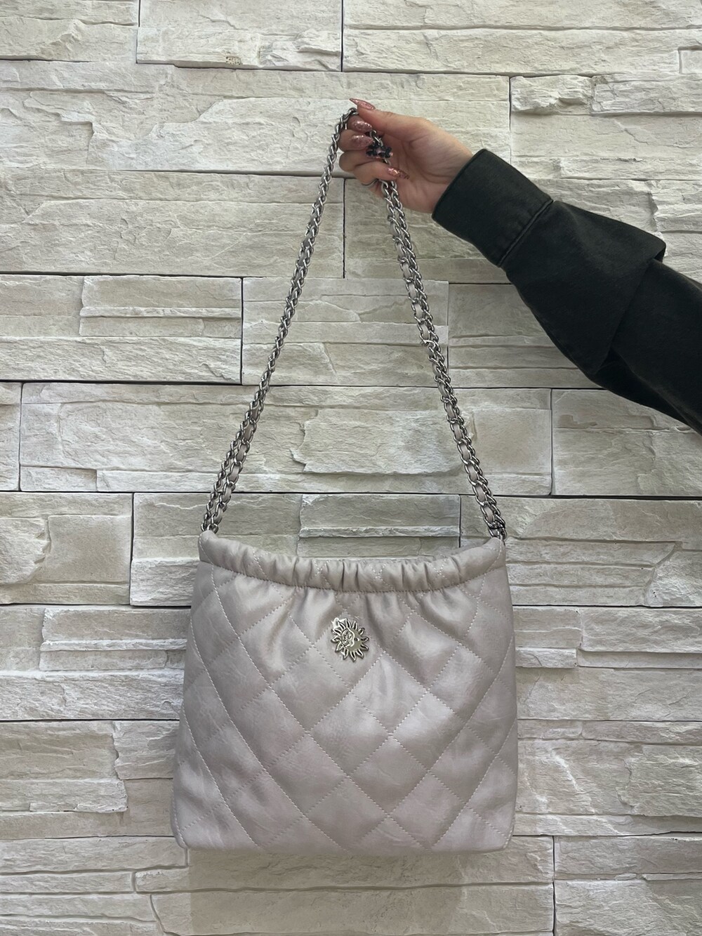 ブラック系のワンピース、ホワイト系のショルダーバッグ、その他のブーツを着用したレディースの冬コーディネートの5枚目の写真