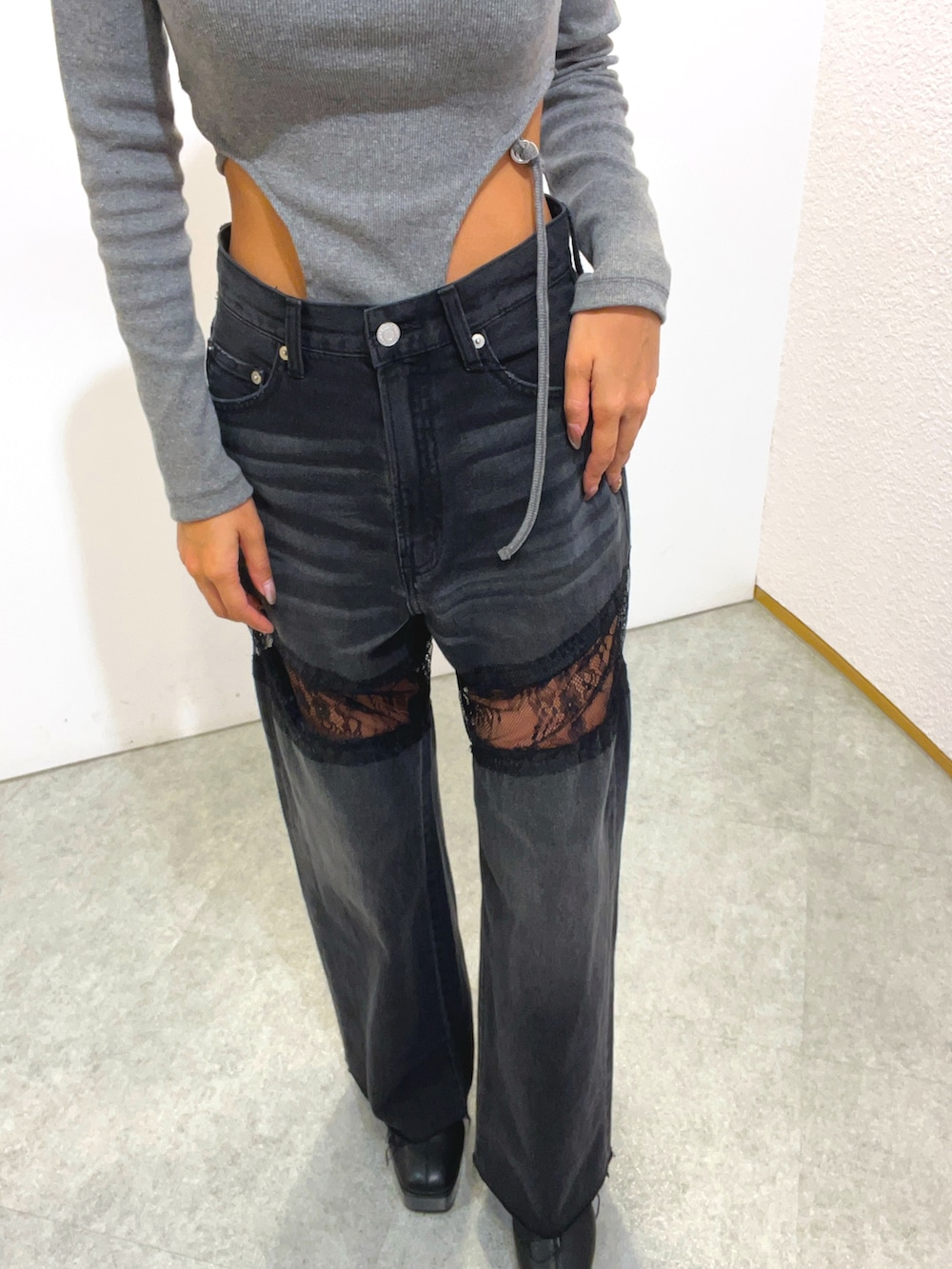 グレー系のTシャツ/カットソー、ブラック系のデニムパンツ、ブラック系のブーツを着用したレディースの秋コーディネートの5枚目の写真