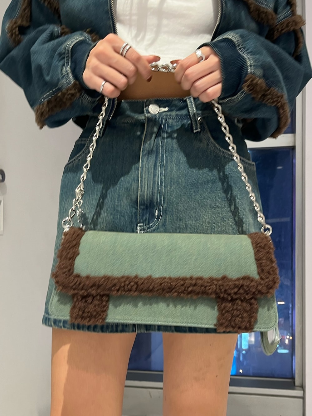 ブルー系のブルゾン、ホワイト系のTシャツ/カットソー、ブルー系のデニムスカートを着用したレディースの秋コーディネートの7枚目の写真