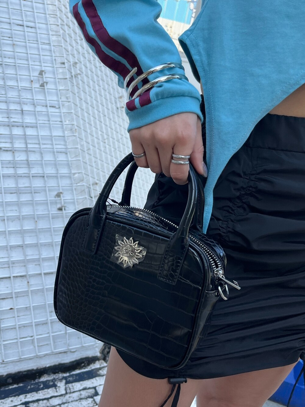 ブルー系のTシャツ/カットソー、ブラック系のスカート、ブラック系のショルダーバッグを着用したレディースの冬コーディネートの5枚目の写真