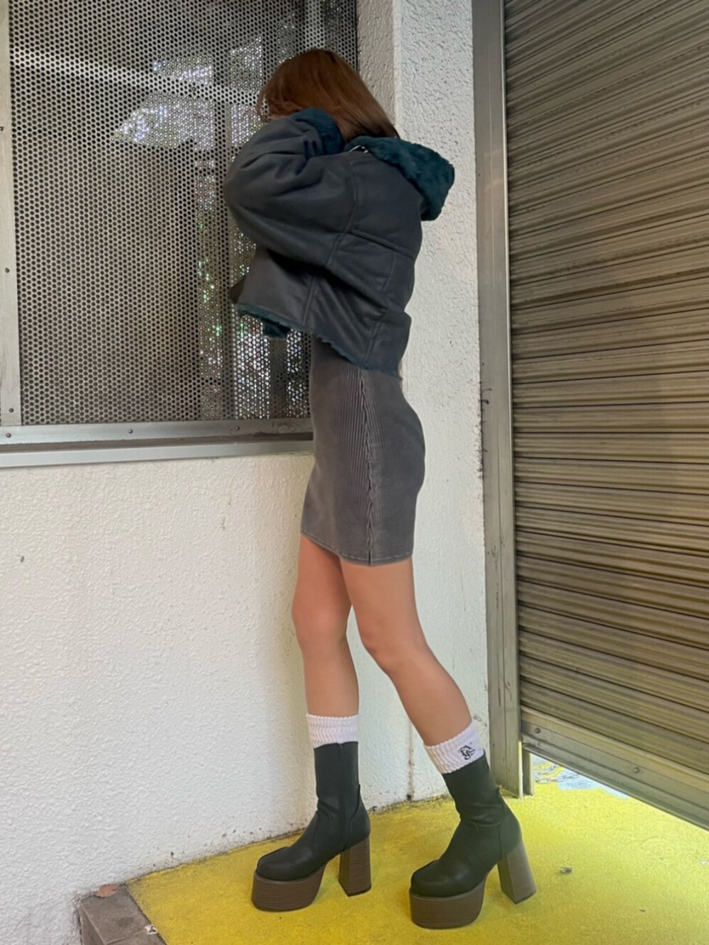 ブルー系のブルゾン、ブラック系のワンピース、ブラック系のブーツを着用したレディースの冬コーディネートの2枚目の写真