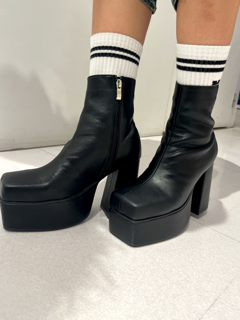 レッド系のニット/セーター、ブルー系のデニムパンツ、ブラック系のハンドバッグを着用したレディースの秋コーディネートの7枚目の写真