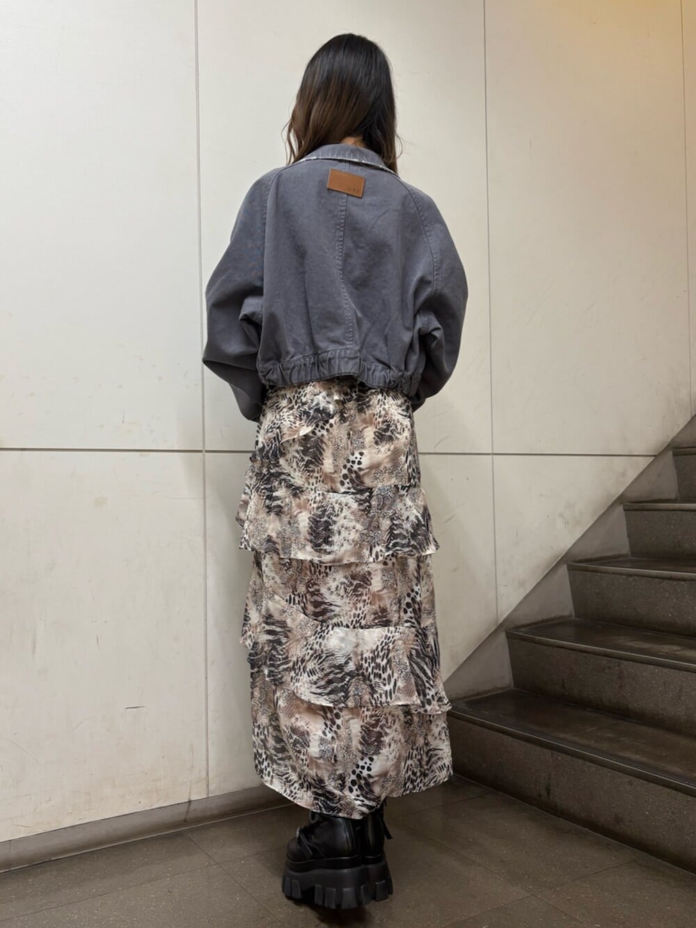 ベージュ系のワンピース、ブラック系のデニムジャケット、ブラウン系のボストンバッグを着用したレディースの春コーディネートの5枚目の写真