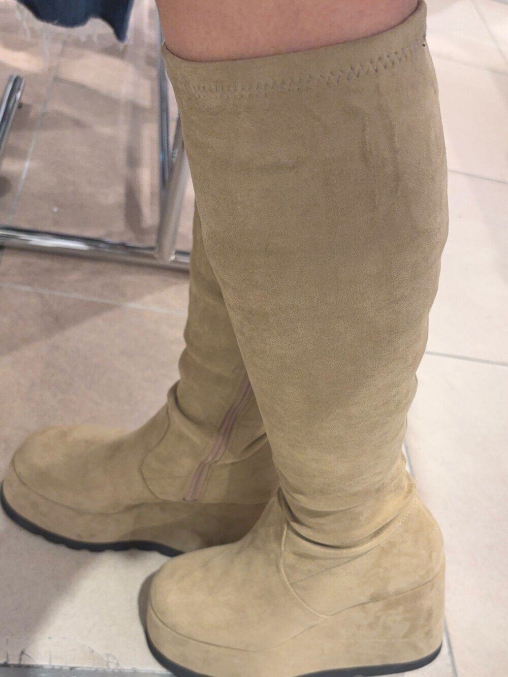 ブルー系のスウェット、ベージュ系のブーツ、ブラック系のキャップを着用したレディースの秋コーディネートの7枚目の写真