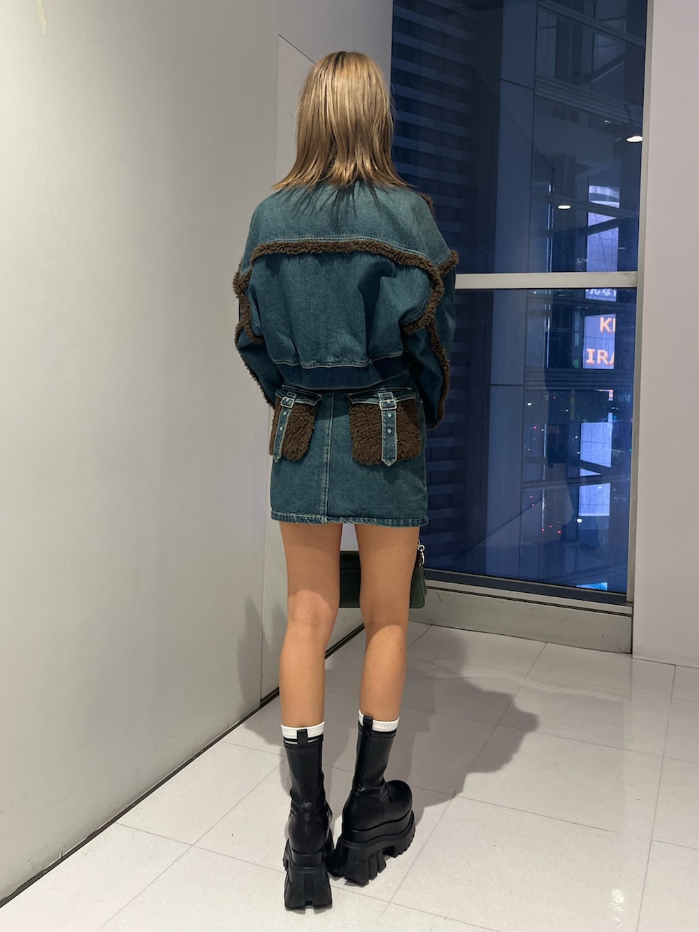 ブルー系のブルゾン、ホワイト系のTシャツ/カットソー、ブルー系のデニムスカートを着用したレディースの秋コーディネートの3枚目の写真