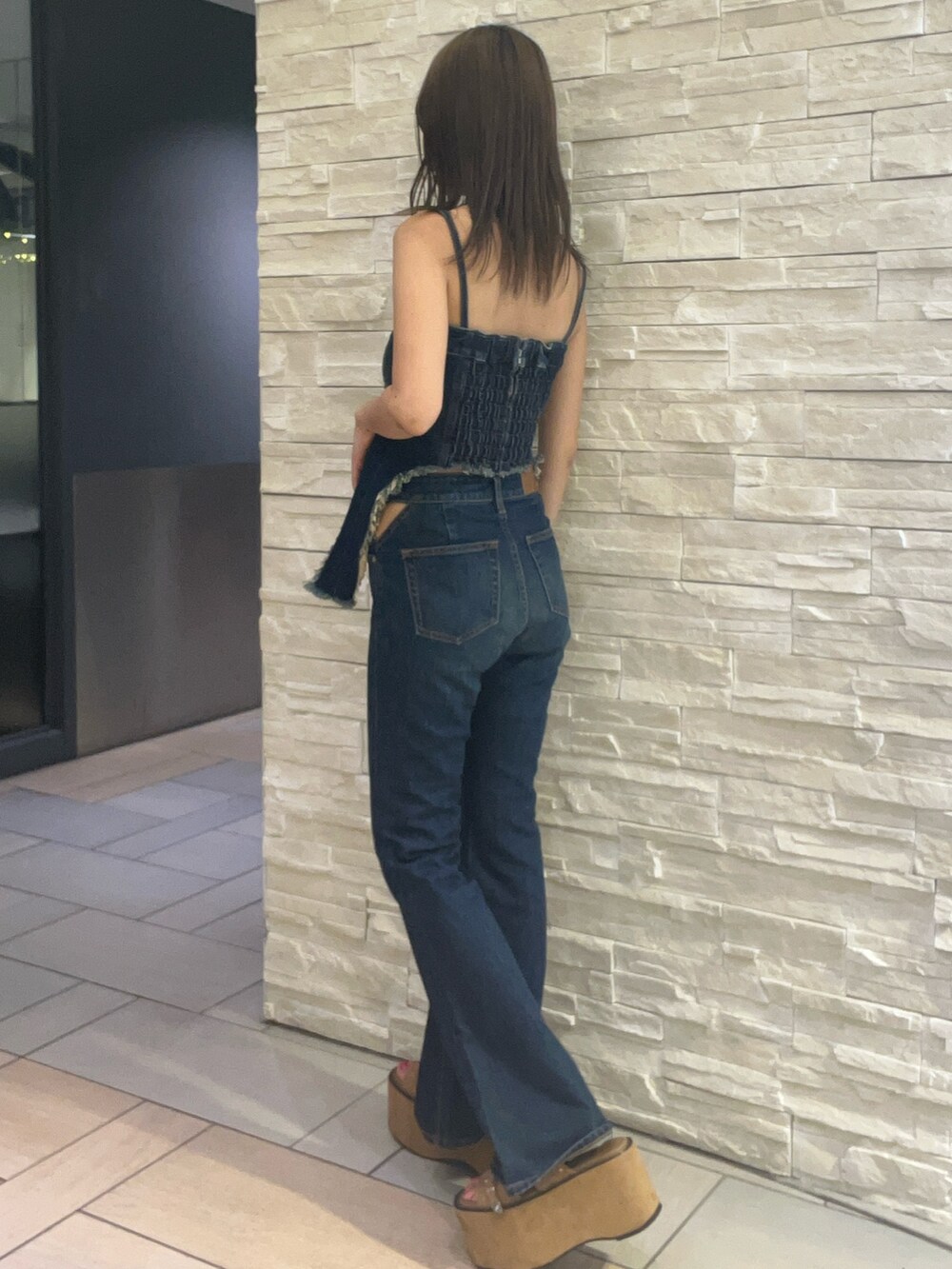 ブルー系のキャミソール、ブルー系のデニムパンツ、ベージュ系のサンダルを着用したレディースの夏コーディネートの2枚目の写真