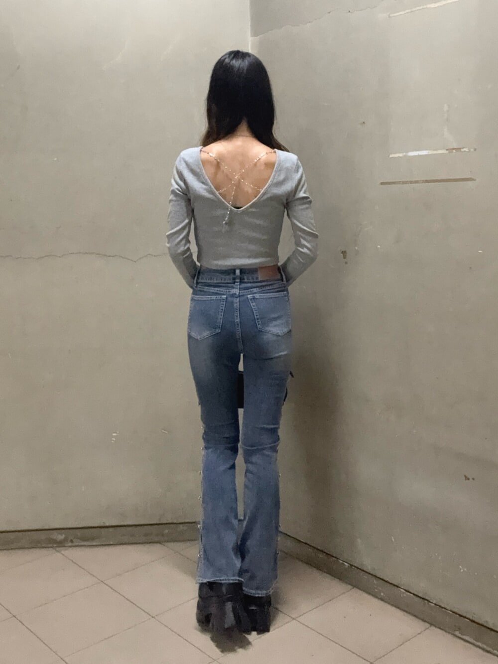 ブラック系のブーツ、グレー系のTシャツ/カットソー、ブラック系のハンドバッグを着用したレディースの秋コーディネートの3枚目の写真