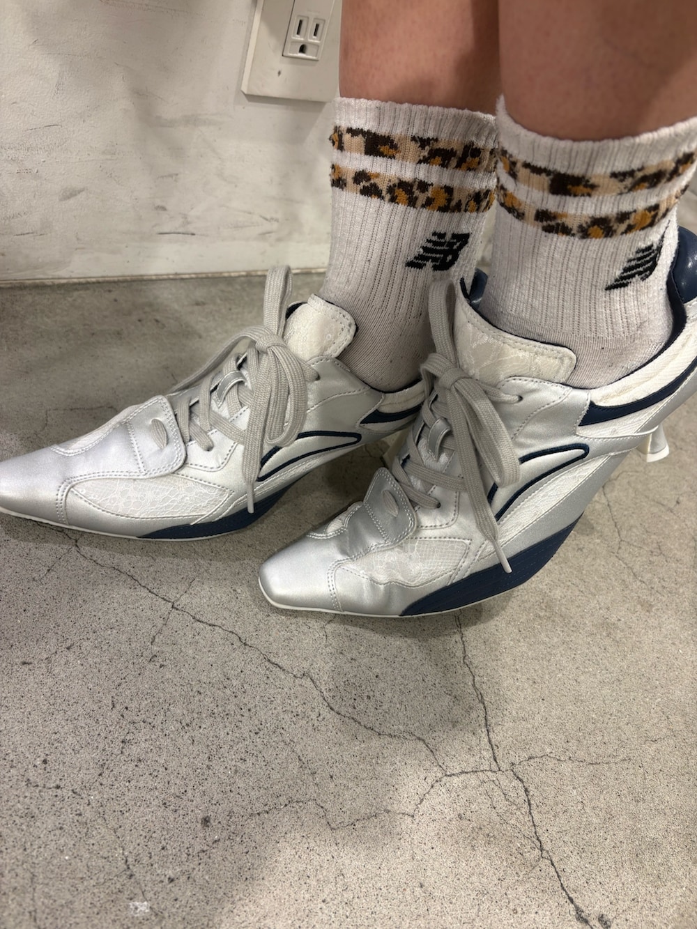 ブルー系のニット/セーター、ブラック系のデニムパンツ、シルバー系のパンプスを着用したレディースの春コーディネートの7枚目の写真