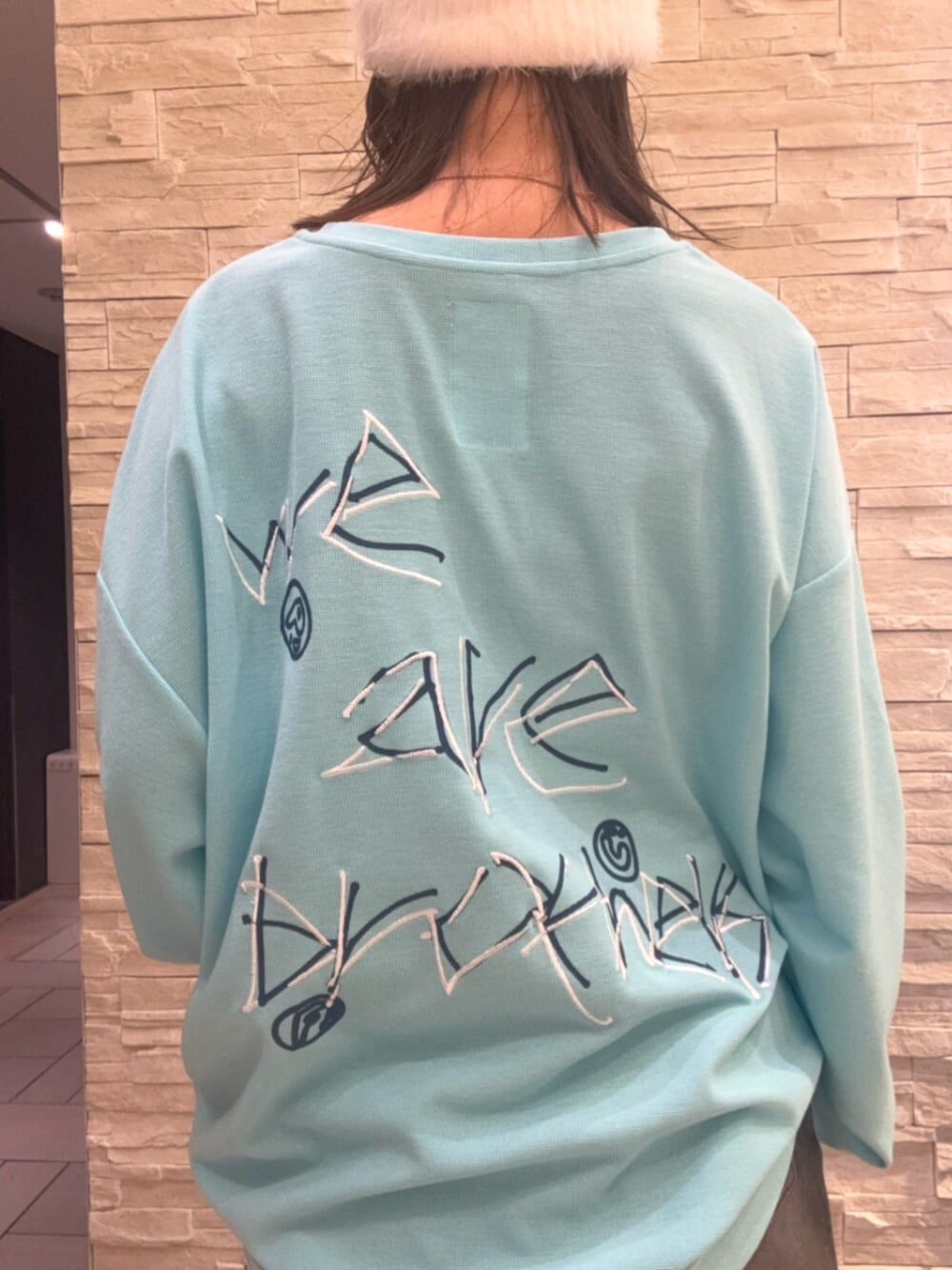ブルー系のTシャツ/カットソー、ブラック系のデニムスカート、ブラウン系のブーツを着用したレディースの秋コーディネートの5枚目の写真