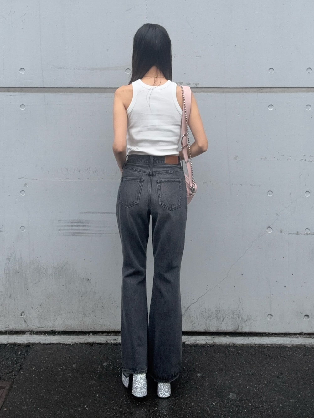 ホワイト系のタンクトップ、ブラック系のデニムパンツ、ピンク系のショルダーバッグを着用したレディースの夏コーディネートの3枚目の写真