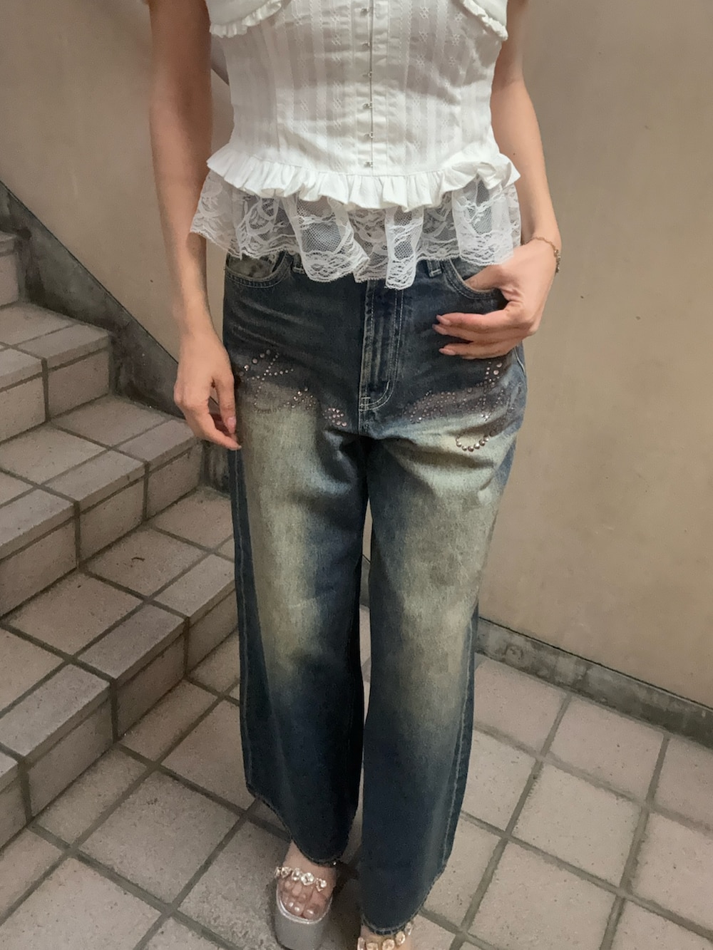 ホワイト系のキャミソール、ブルー系のデニムパンツ、シルバー系のサンダルを着用したレディースの春コーディネートの5枚目の写真