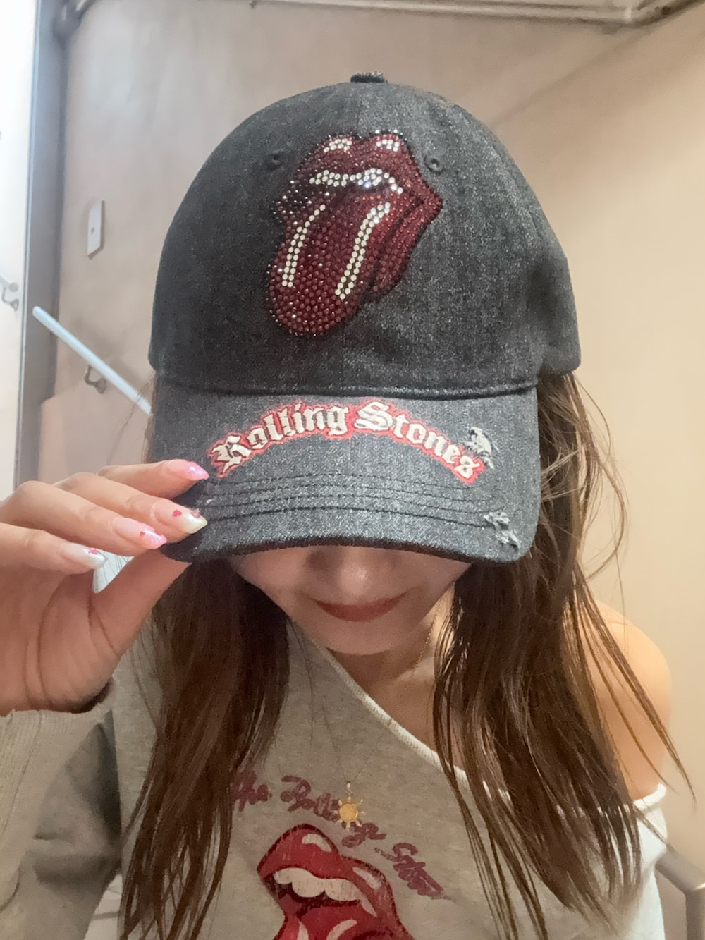 グレー系のスウェット、ブルー系のデニムスカート、ブラック系のキャップを着用したレディースの春コーディネートの4枚目の写真