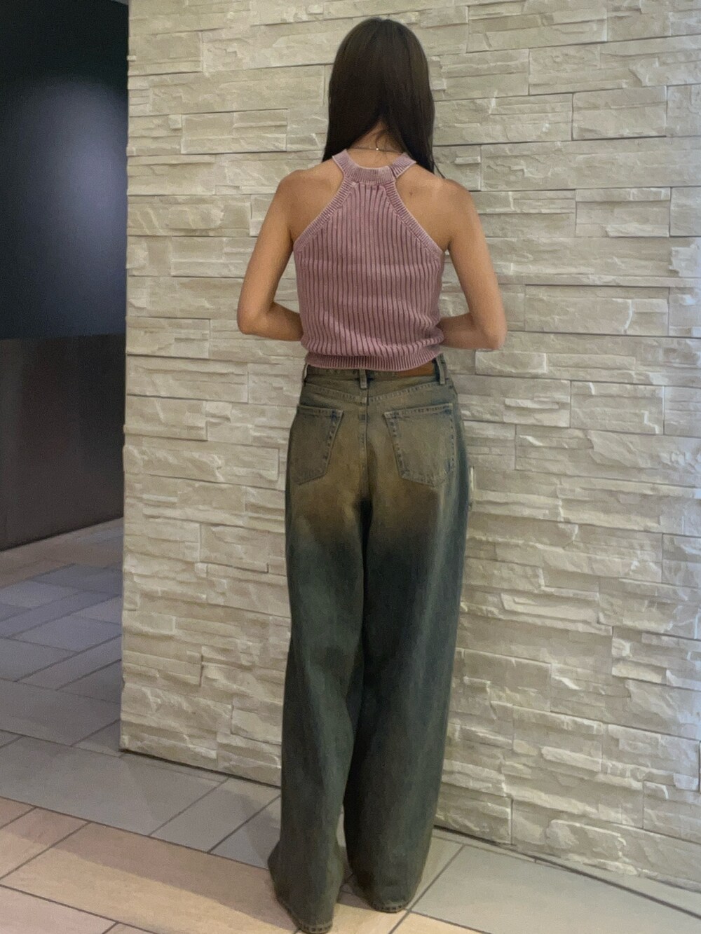 ピンク系のニット/セーター、ブルー系のデニムパンツを着用したレディースの夏コーディネートの3枚目の写真