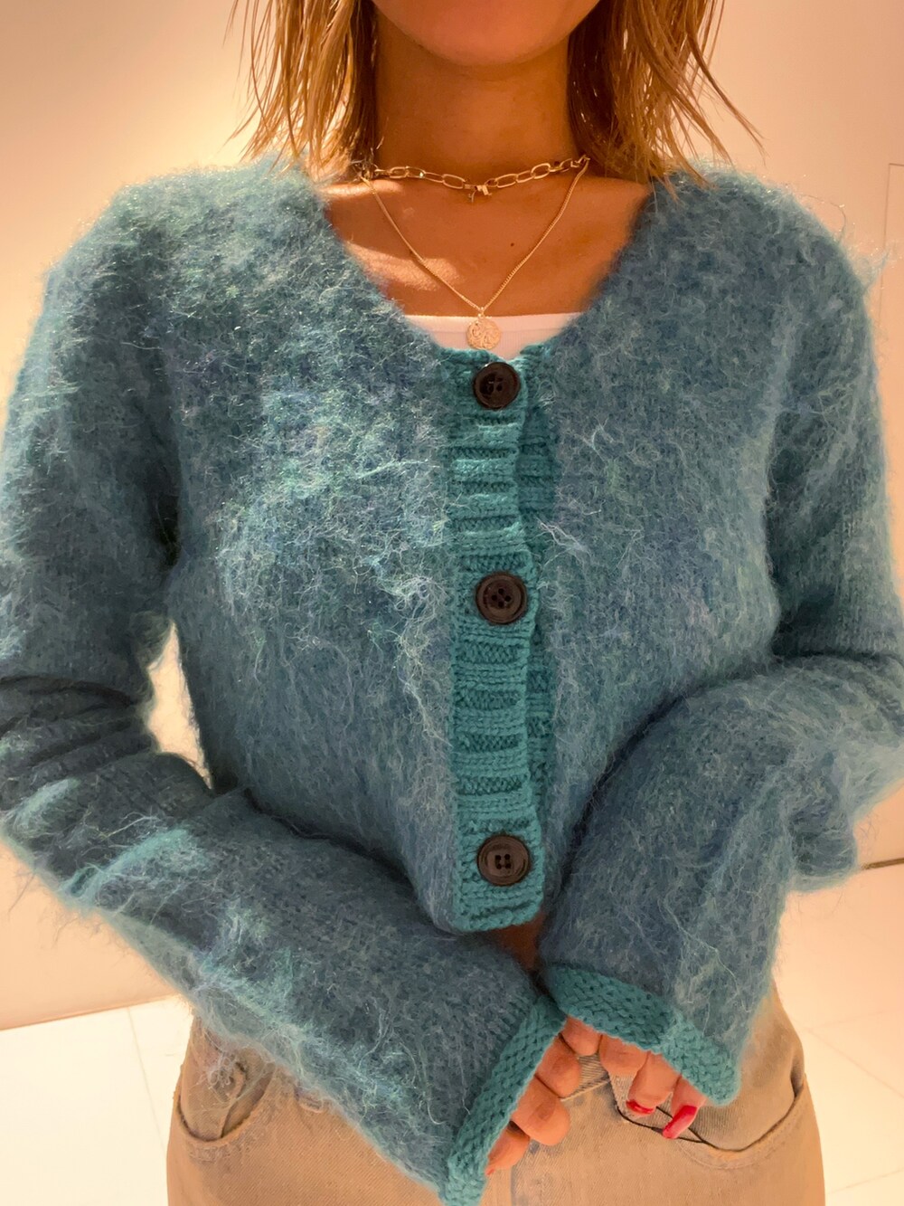 ブルー系のニット/セーター、ブルー系のデニムパンツ、ブラック系のローファーを着用したレディースの秋コーディネートの4枚目の写真