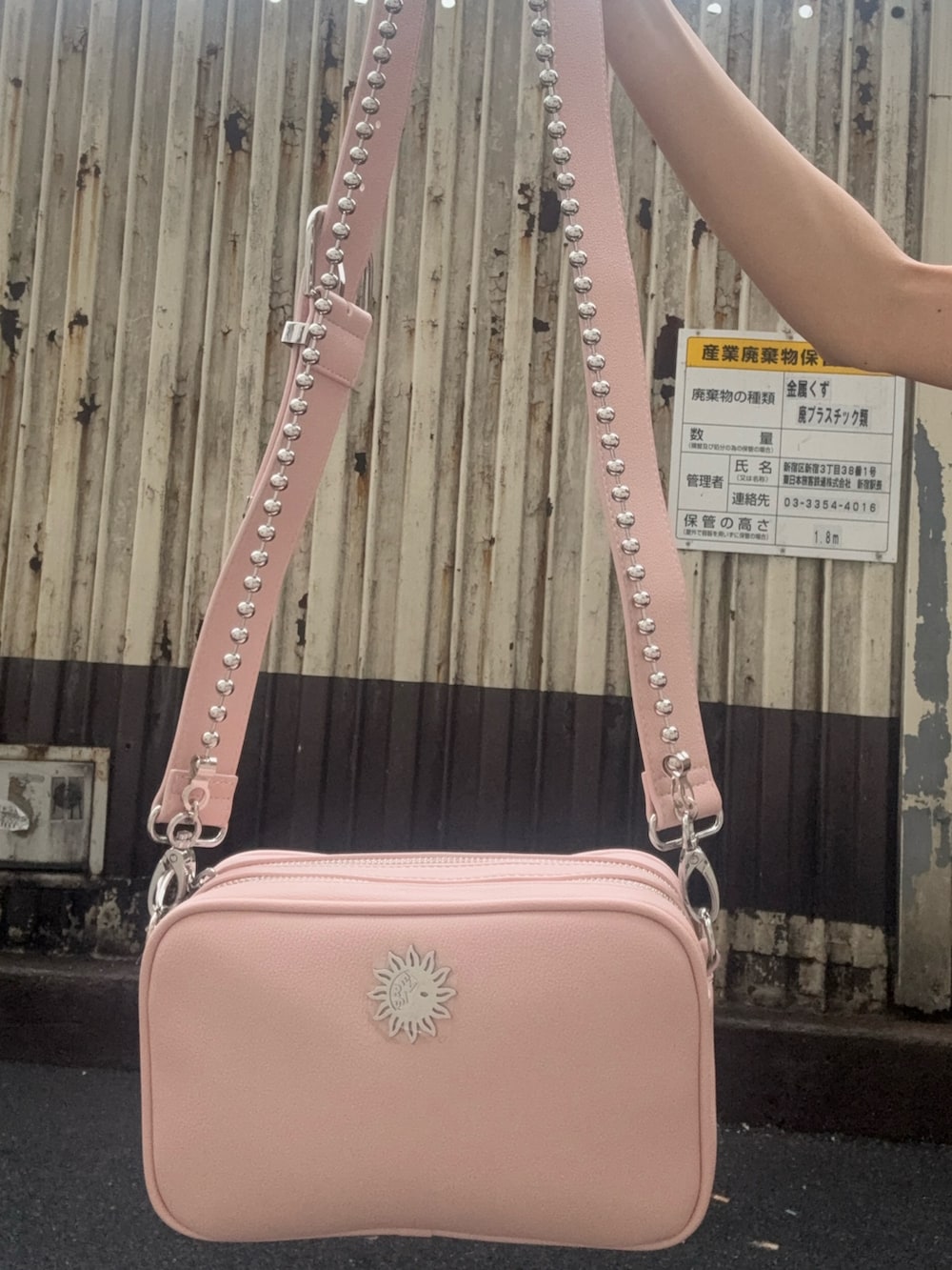 ホワイト系のタンクトップ、ブラック系のデニムパンツ、ピンク系のショルダーバッグを着用したレディースの夏コーディネートの6枚目の写真