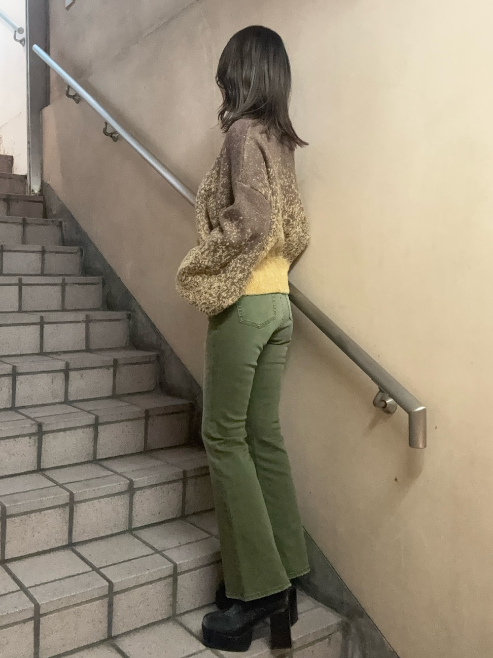 その他のブーツ、ブラウン系のニット/セーター、グリーン系のデニムパンツを着用したレディースの冬コーディネートの2枚目の写真