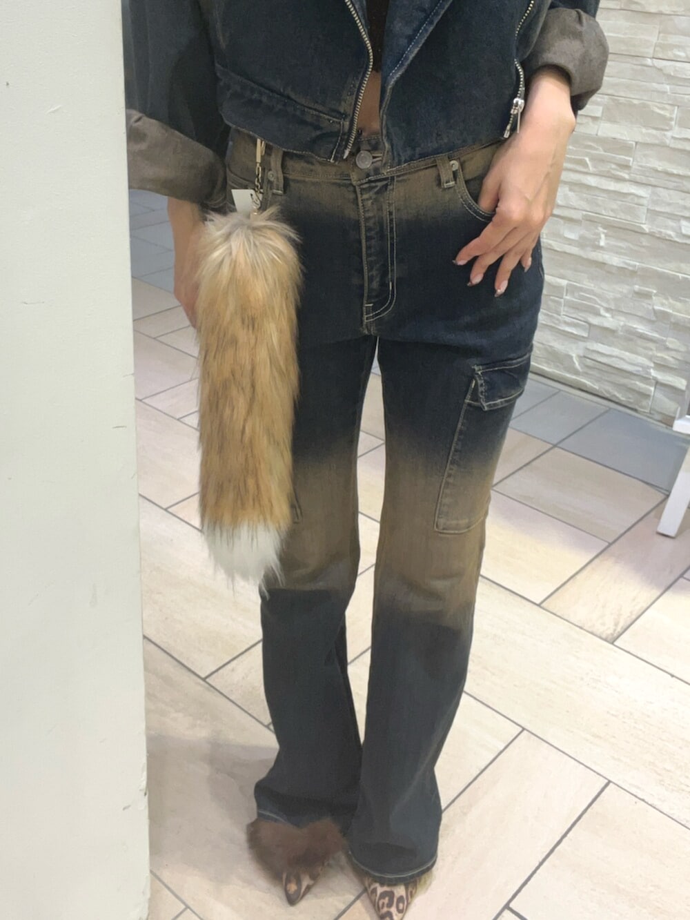 ブルー系のデニムジャケット、ブルー系のデニムパンツ、ブラウン系のタンクトップを着用したレディースの秋コーディネートの5枚目の写真