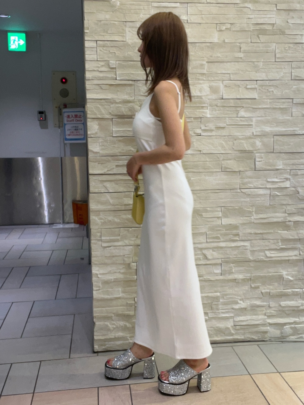 ホワイト系のワンピース、イエロー系のショルダーバッグ、シルバー系のサンダルを着用したレディースの夏コーディネートの2枚目の写真