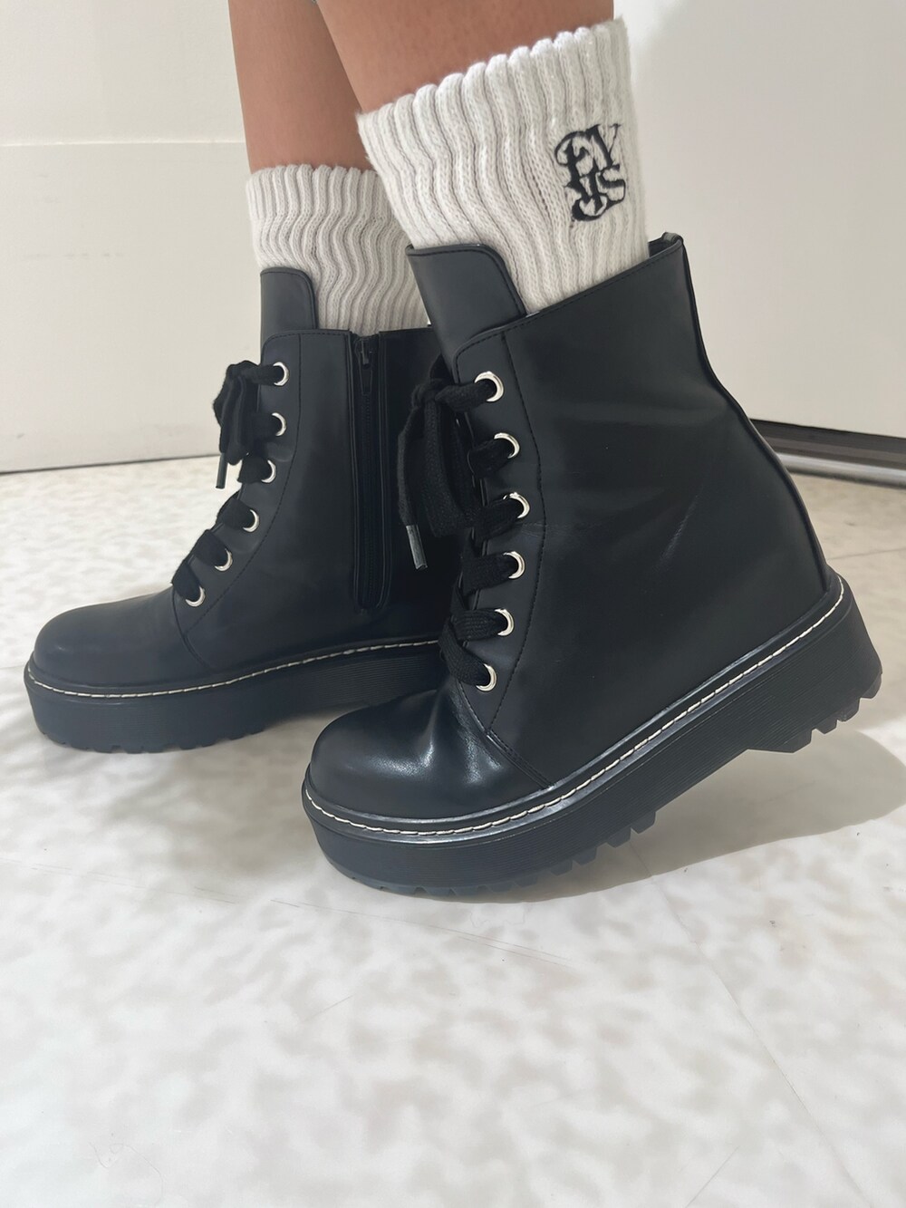 ブラック系のニット/セーター、ホワイト系のTシャツ/カットソー、ブルー系のデニムパンツを着用したレディースの秋コーディネートの7枚目の写真