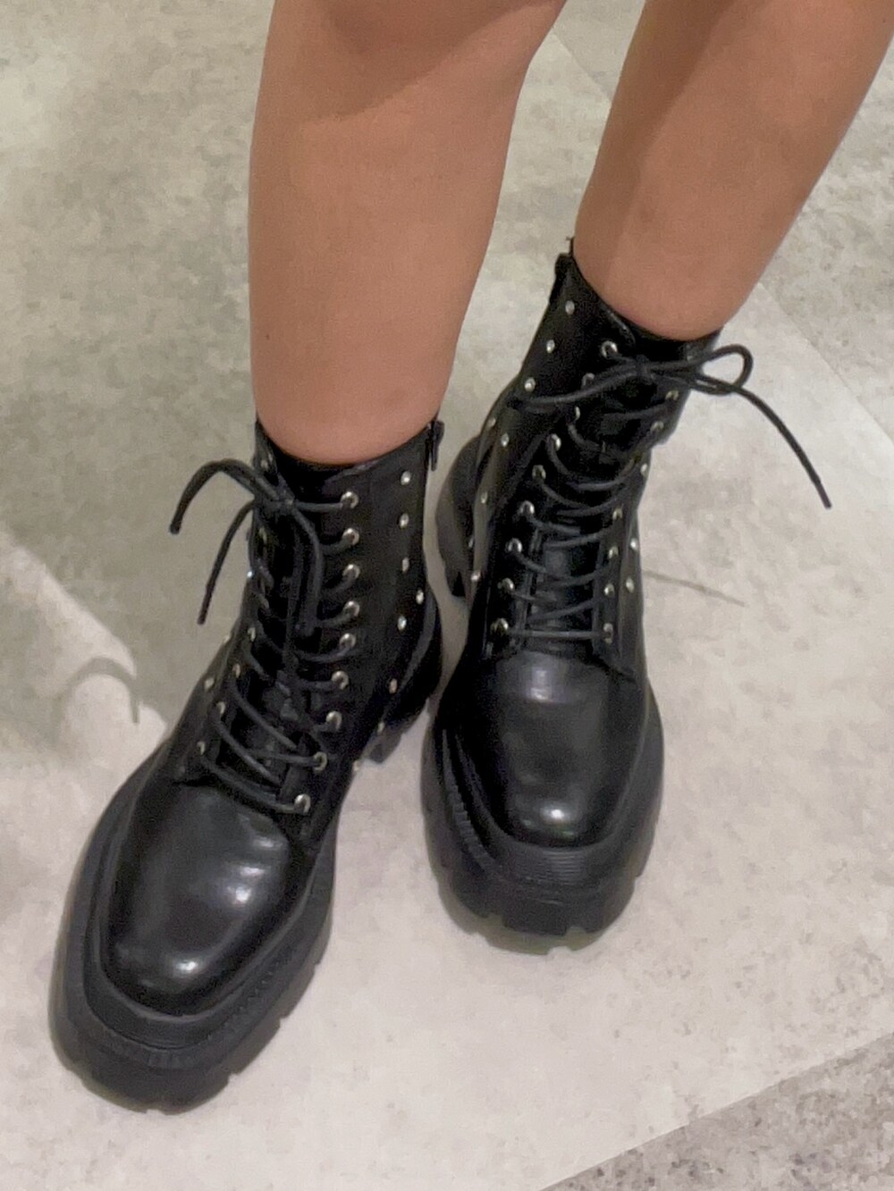 ブラック系のワンピース、ブラック系のブーツ、シルバー系のチョーカーを着用したレディースの春コーディネートの4枚目の写真