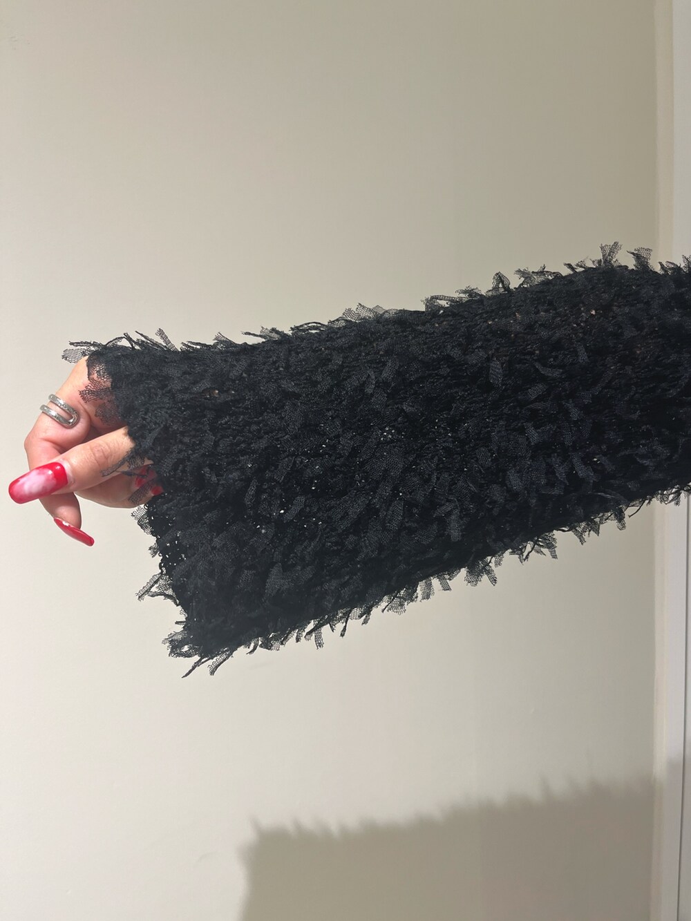 ブラック系のニット/セーター、ホワイト系のTシャツ/カットソー、ブルー系のデニムパンツを着用したレディースの秋コーディネートの5枚目の写真