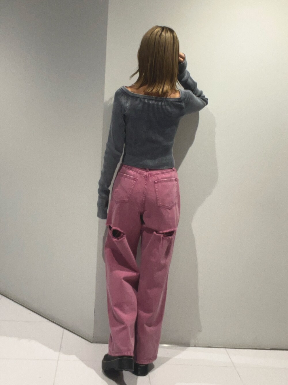 ブルー系のニット/セーター、ピンク系のデニムパンツ、ブラック系のハンドバッグを着用したレディースの夏コーディネートの3枚目の写真