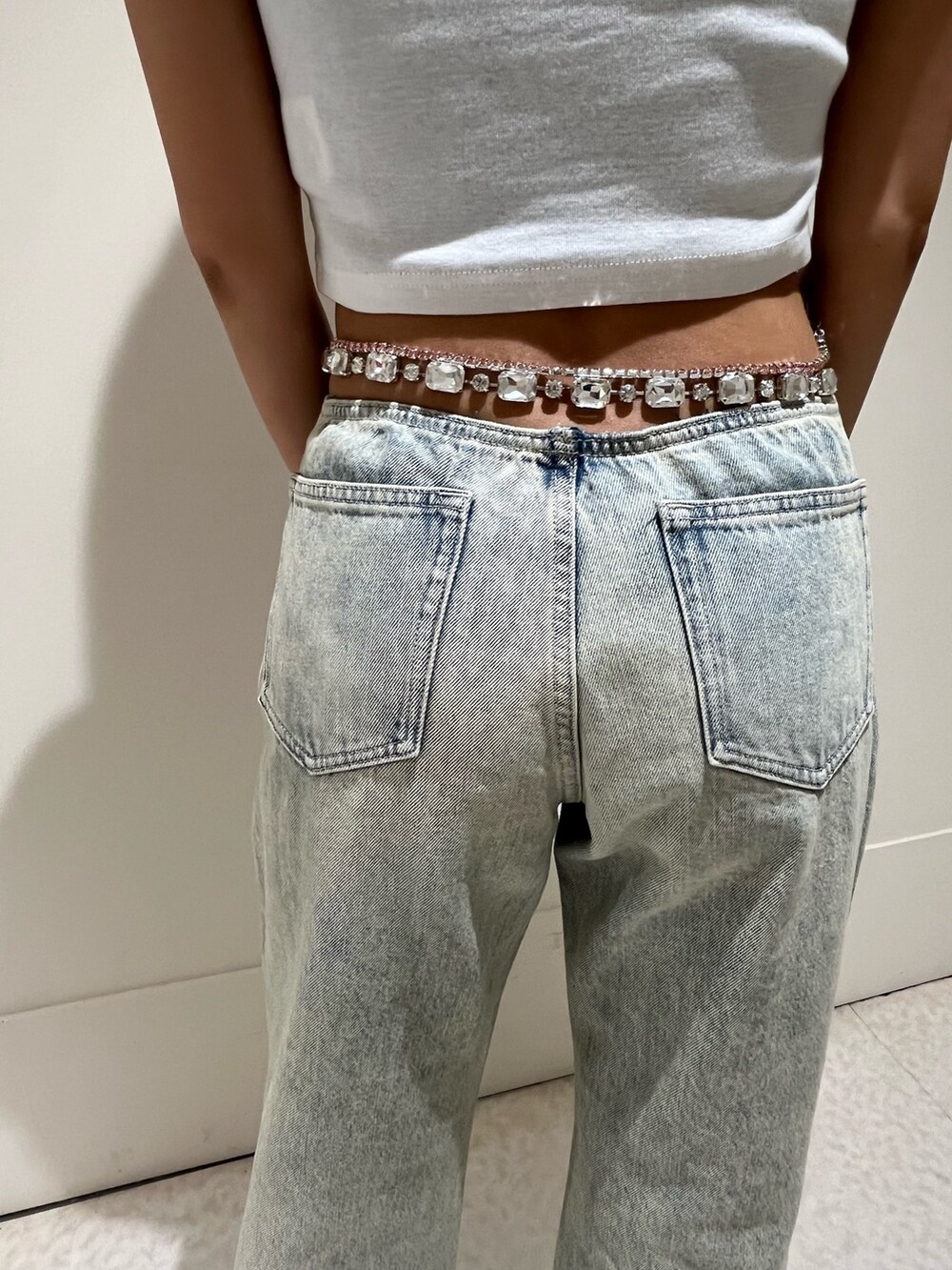 ホワイト系のTシャツ/カットソー、ブラック系のサンダル、ブルー系のデニムパンツを着用したレディースの夏コーディネートの4枚目の写真