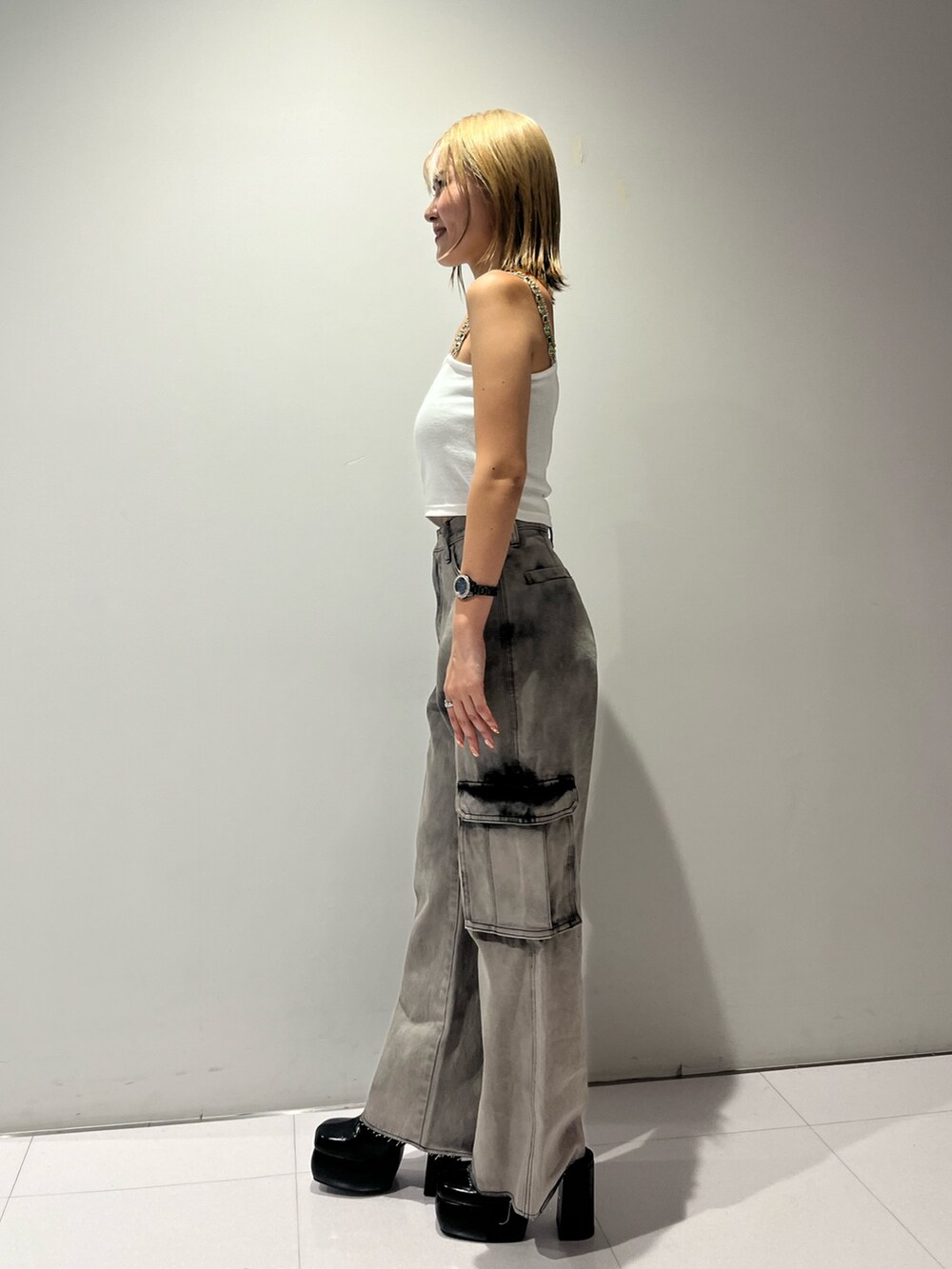 ホワイト系のタンクトップ、ブラック系のデニムパンツ、ブラック系のサンダルを着用したレディースの夏コーディネートの4枚目の写真