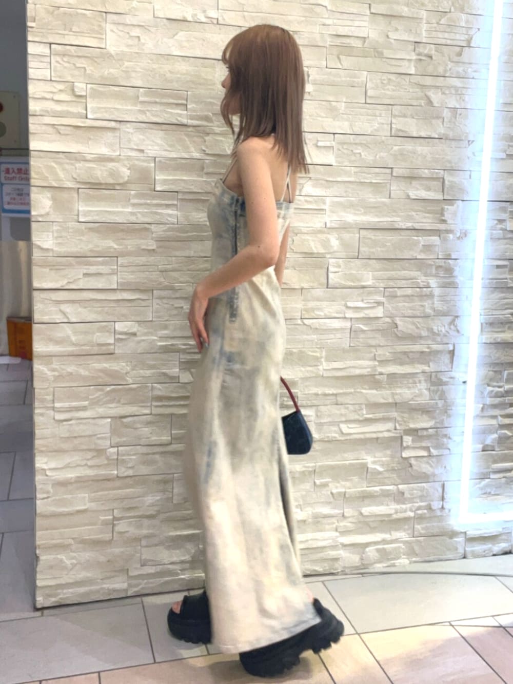 その他のワンピース、ブルー系のハンドバッグ、ブラック系のサンダルを着用したレディースの春コーディネートの2枚目の写真