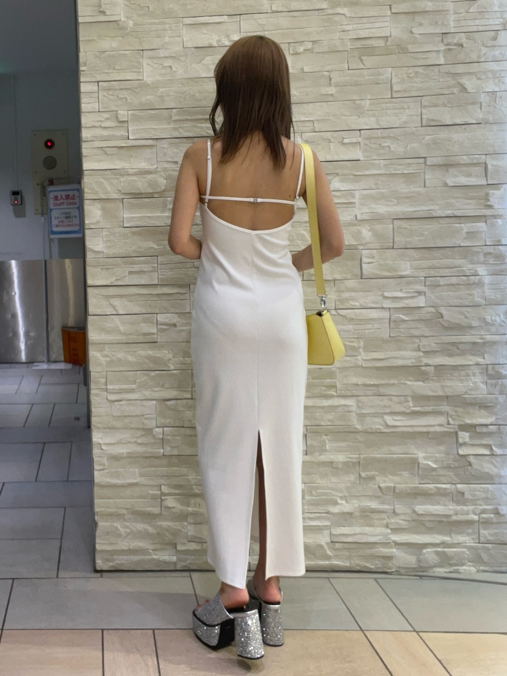 ホワイト系のワンピース、イエロー系のショルダーバッグ、シルバー系のサンダルを着用したレディースの夏コーディネートの3枚目の写真