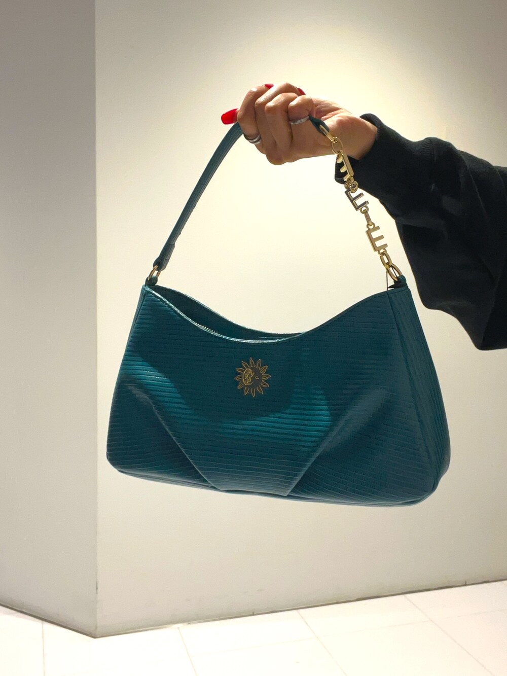 ブラック系のパーカー、ブルー系のハンドバッグ、ホワイト系のその他パンツを着用したレディースの秋コーディネートの5枚目の写真