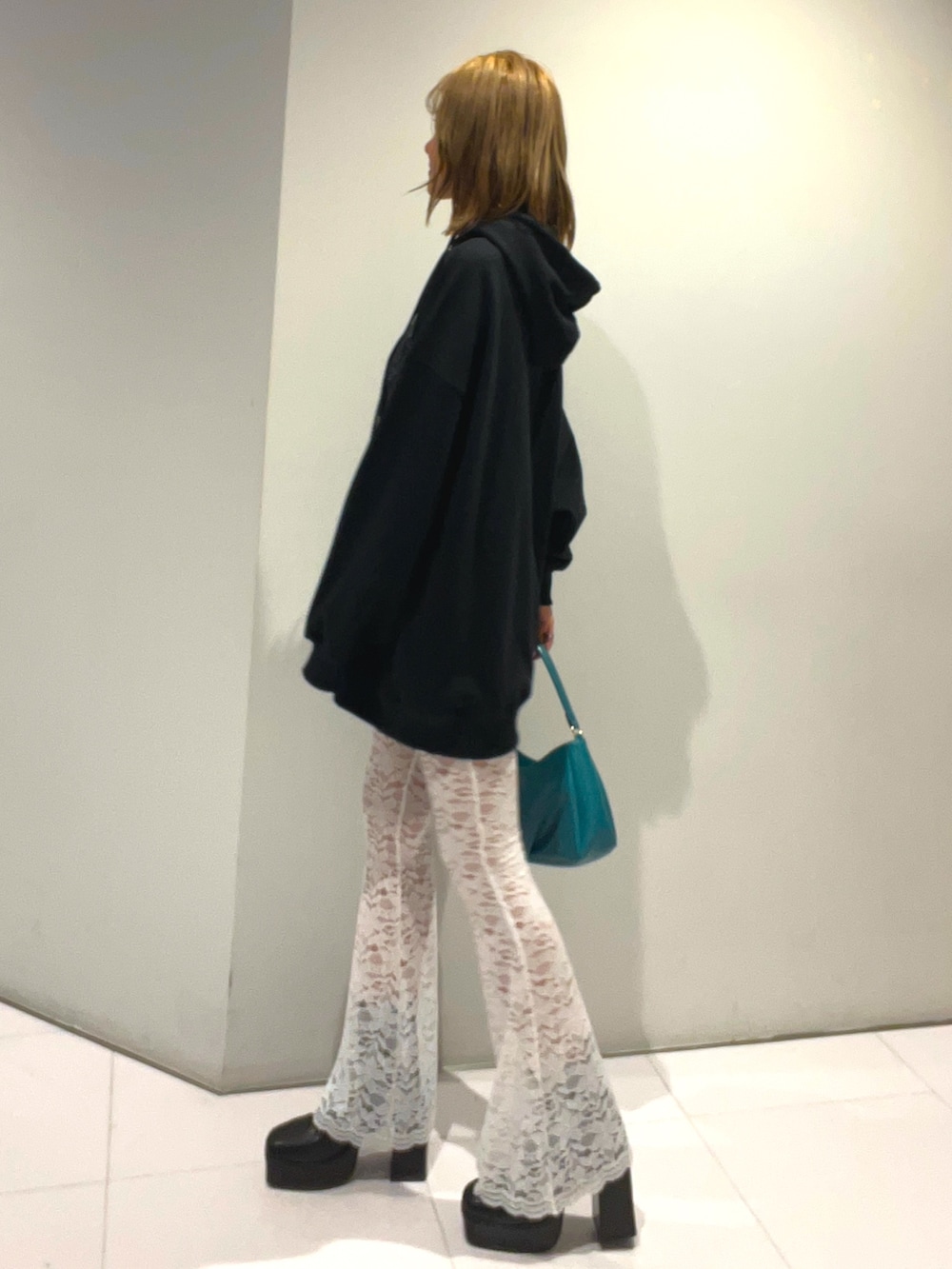 ブラック系のパーカー、ブルー系のハンドバッグ、ホワイト系のその他パンツを着用したレディースの秋コーディネートの2枚目の写真