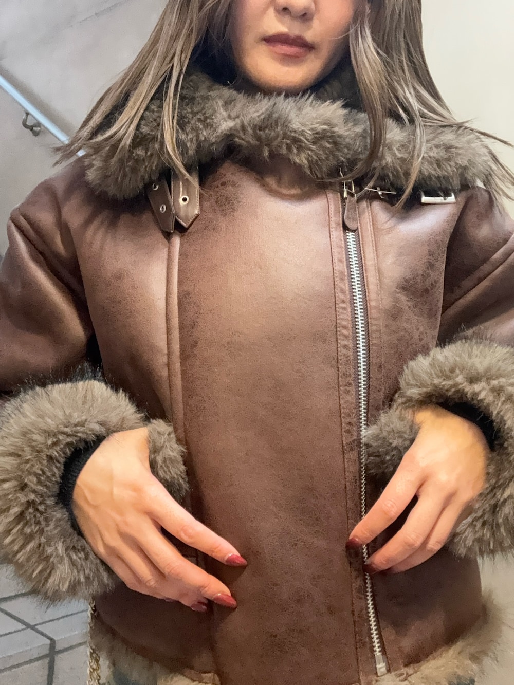 ブラウン系のブルゾン、ブラック系のTシャツ/カットソー、ブルー系のデニムパンツを着用したレディースの秋コーディネートの6枚目の写真