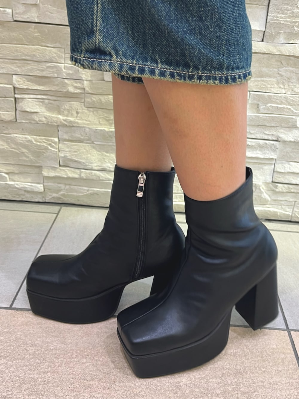 ピンク系のニット/セーター、ブルー系のデニムパンツ、ブラック系のショルダーバッグを着用したレディースの秋コーディネートの6枚目の写真