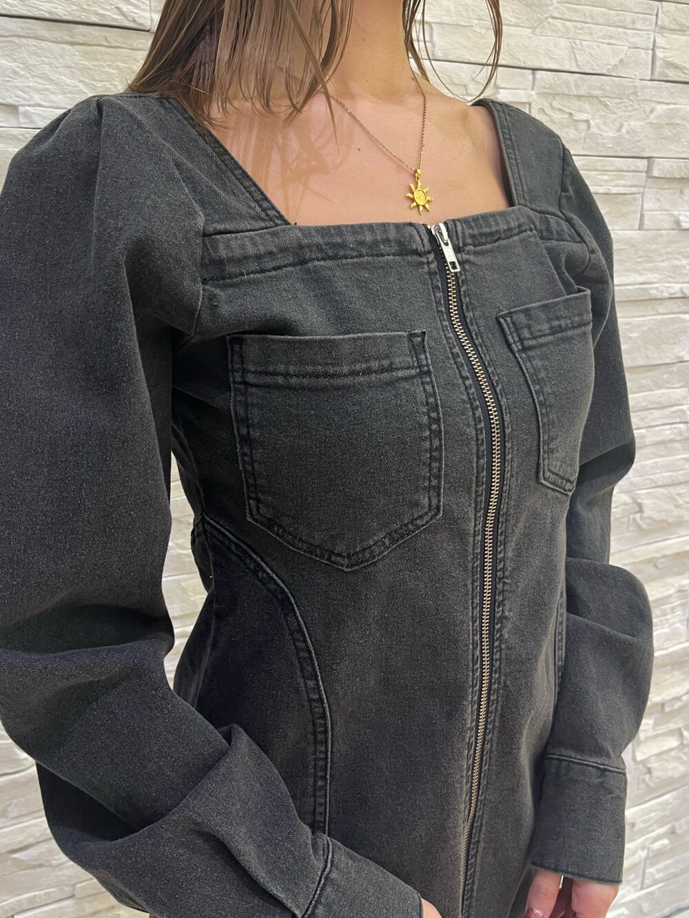 ブラック系のワンピース、ホワイト系のショルダーバッグ、その他のブーツを着用したレディースの冬コーディネートの4枚目の写真