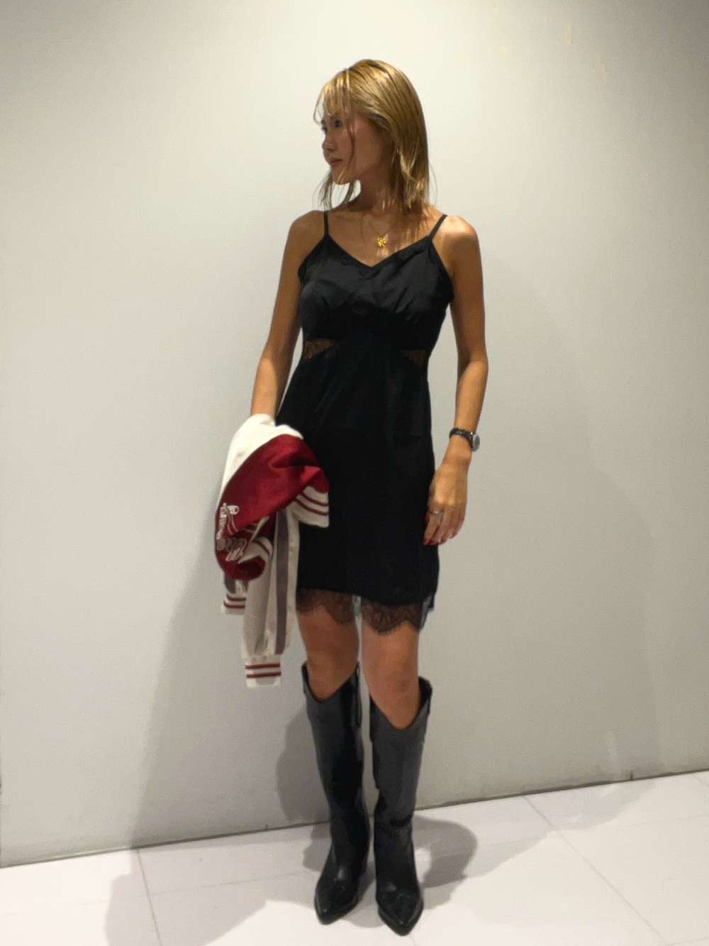 レッド系のブルゾン、ブラック系のワンピース、ブラック系のショルダーバッグを着用したレディースの秋コーディネートの2枚目の写真