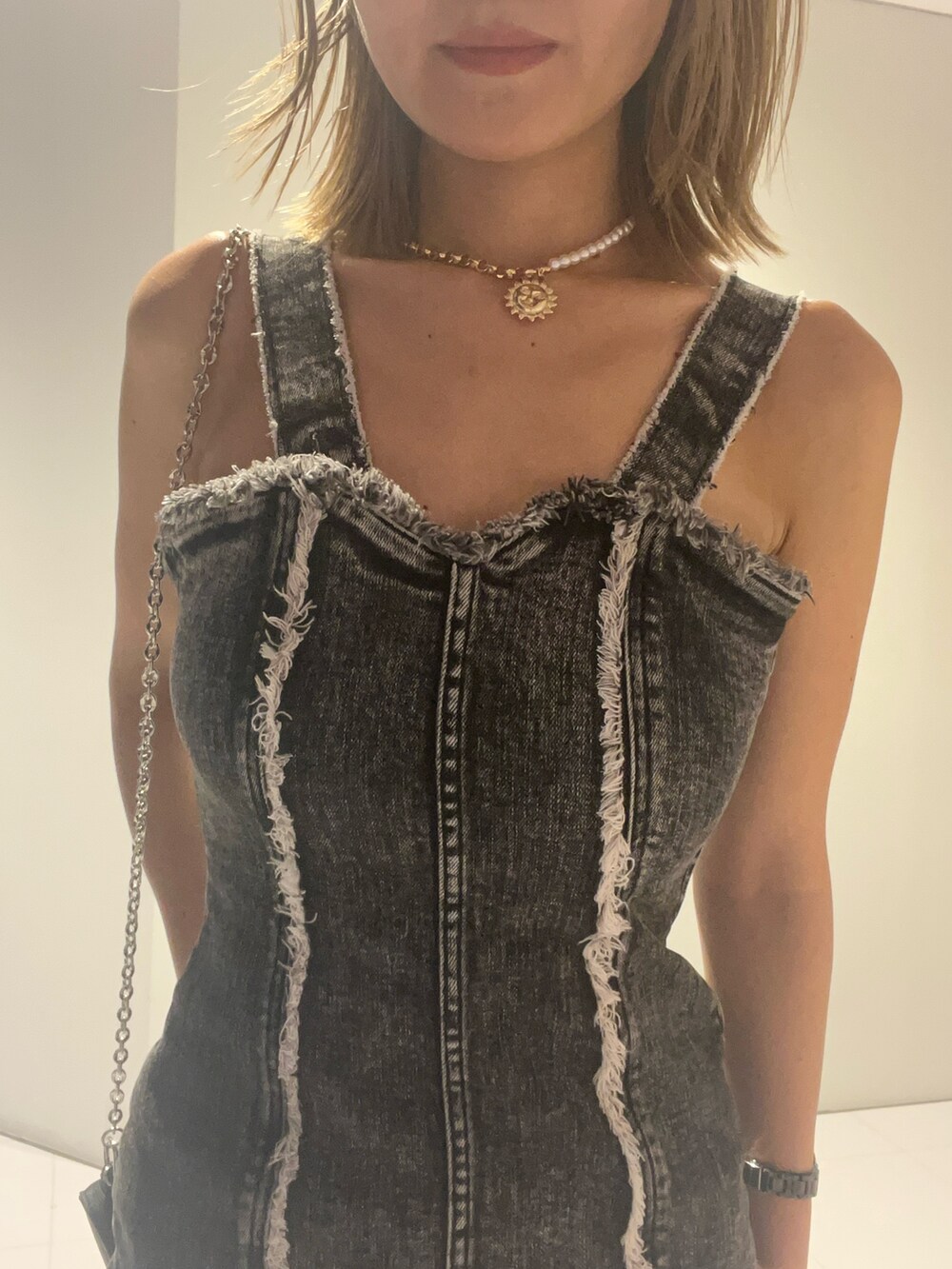 ブラック系のワンピース、ブラック系のショルダーバッグ、ブラック系のブーツを着用したレディースの夏コーディネートの4枚目の写真