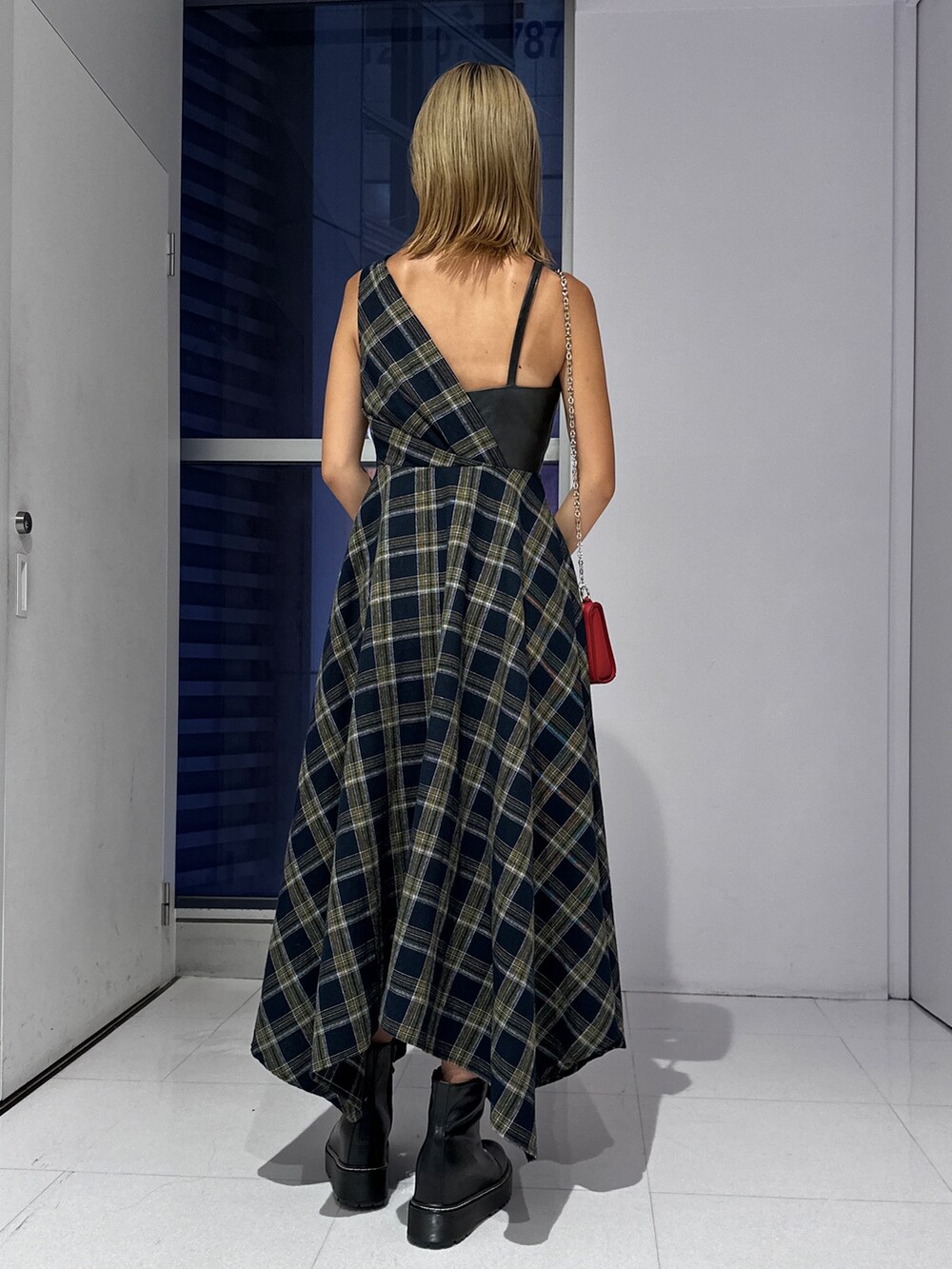 ブルー系のワンピース、レッド系のショルダーバッグ、ブラック系のブーツを着用したレディースの秋コーディネートの3枚目の写真