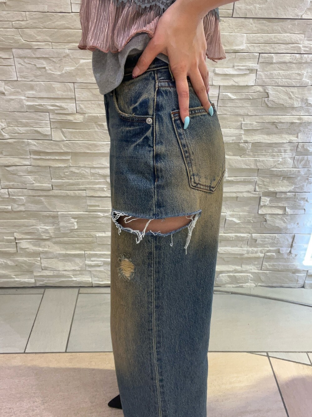 グレー系のTシャツ/カットソー、ピンク系のキャミソール、ブルー系のデニムパンツを着用したレディースの春コーディネートの6枚目の写真