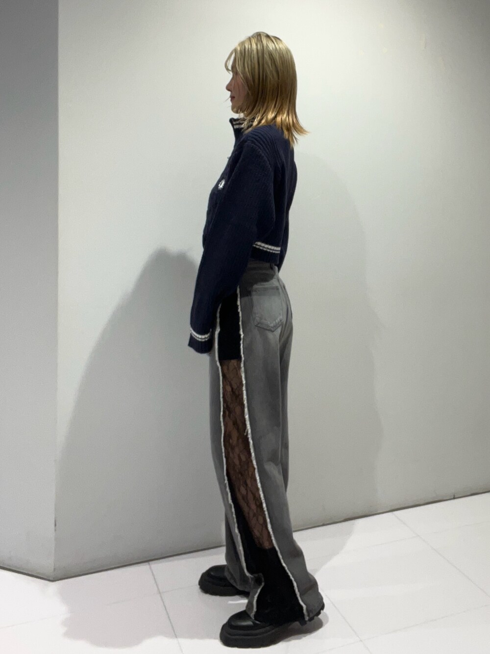 ブルー系のニット/セーター、ブラック系のショルダーバッグ、ブラック系のデニムパンツを着用したレディースの夏コーディネートの4枚目の写真