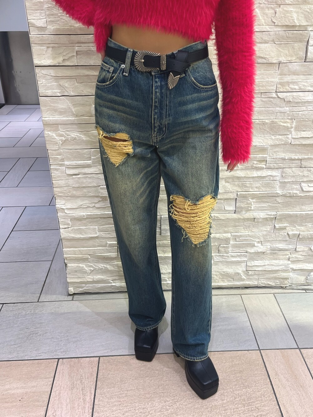 ピンク系のニット/セーター、ブルー系のデニムパンツ、ブラック系のショルダーバッグを着用したレディースの秋コーディネートの5枚目の写真