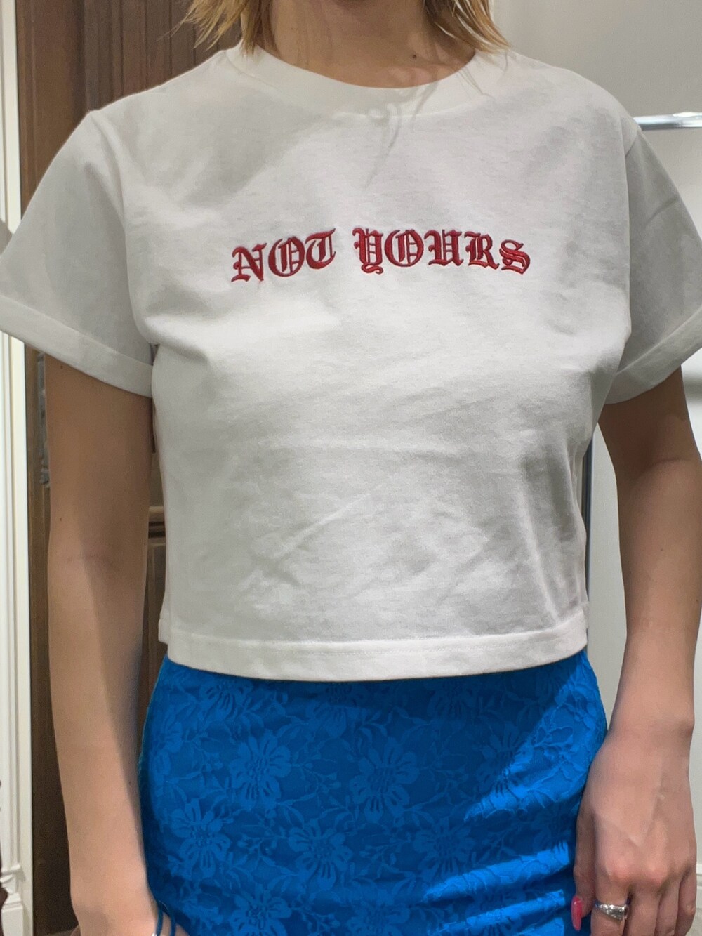 ホワイト系のTシャツ/カットソー、ブルー系のスカート、ブラック系のショルダーバッグを着用したレディースの春コーディネートの2枚目の写真