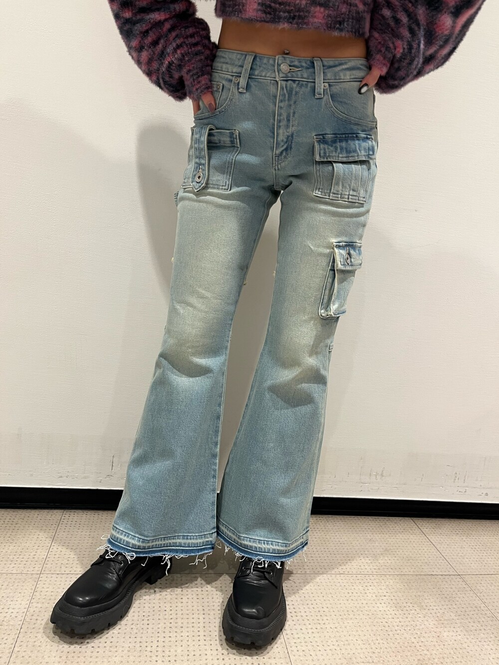 ピンク系のニット/セーター、シルバー系のボディバッグ/ウエストポーチ、ブルー系のデニムパンツを着用したレディースの冬コーディネートの4枚目の写真