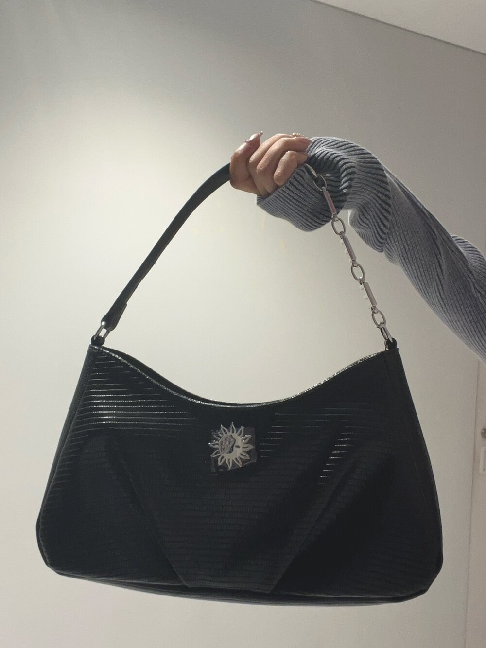 ブルー系のニット/セーター、ピンク系のデニムパンツ、ブラック系のハンドバッグを着用したレディースの夏コーディネートの7枚目の写真