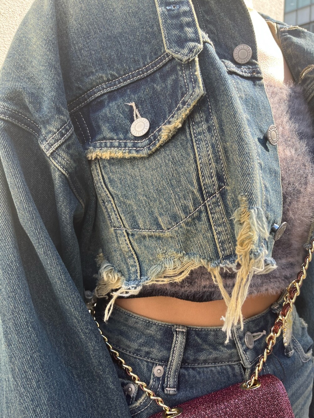 ブルー系のデニムジャケット、ブルー系のデニムパンツ、ピンク系のショルダーバッグを着用したレディースの冬コーディネートの5枚目の写真