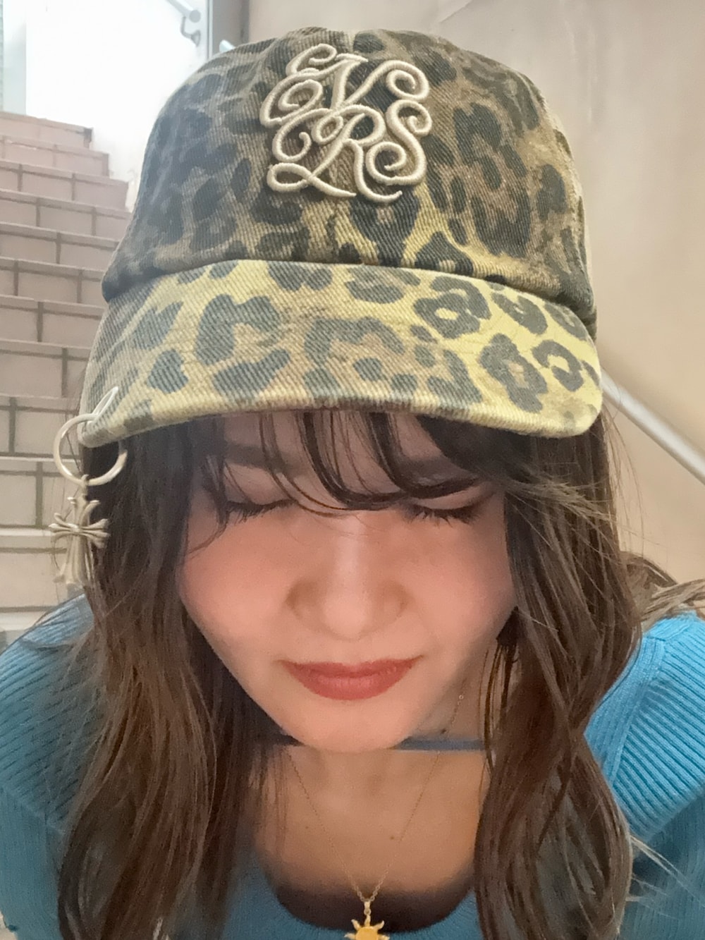 ブルー系のニット/セーター、ブラック系のデニムパンツ、シルバー系のパンプスを着用したレディースの春コーディネートの4枚目の写真