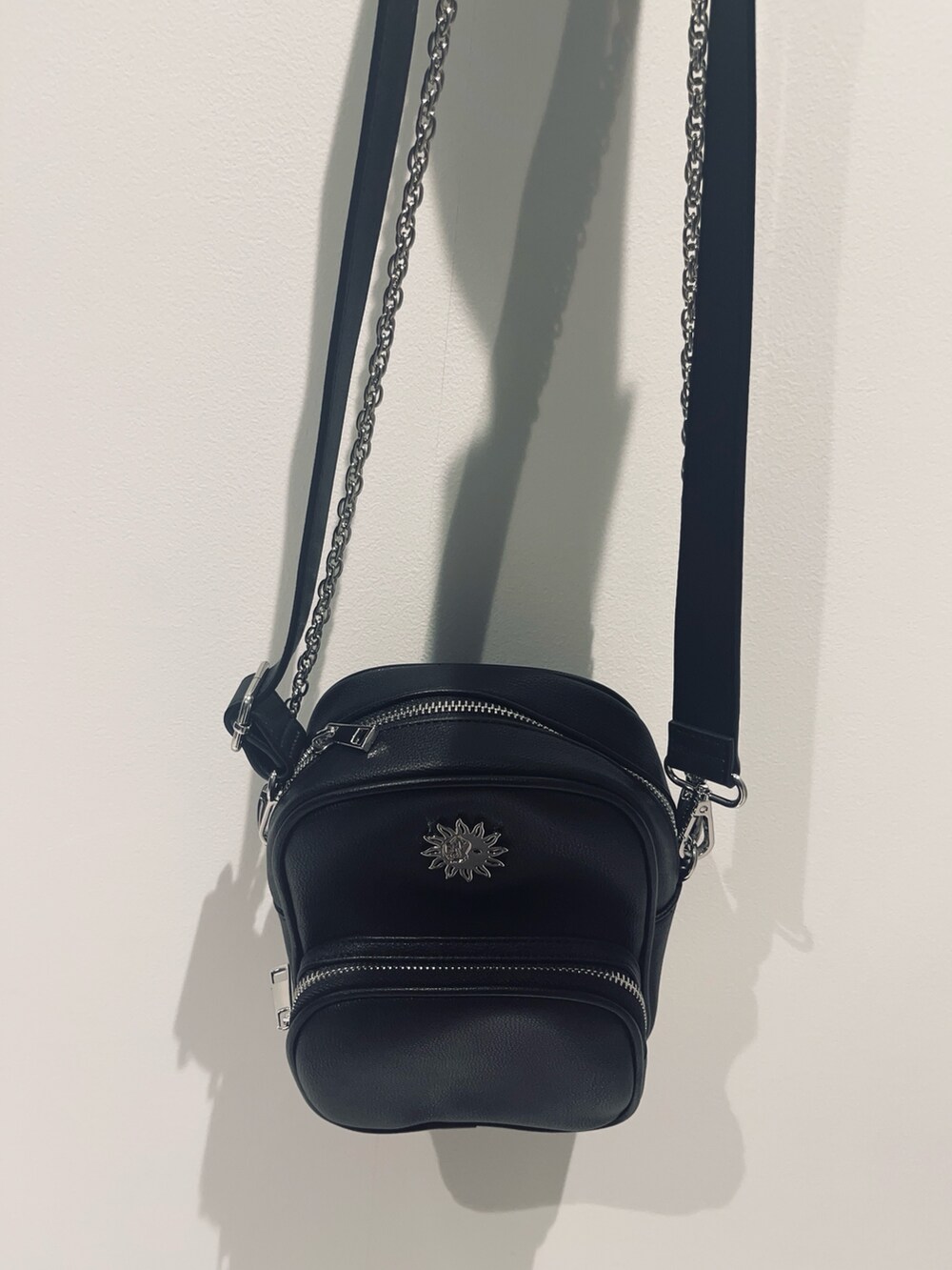 ブルー系のニット/セーター、ブラック系のショルダーバッグ、ブラック系のデニムパンツを着用したレディースの夏コーディネートの6枚目の写真