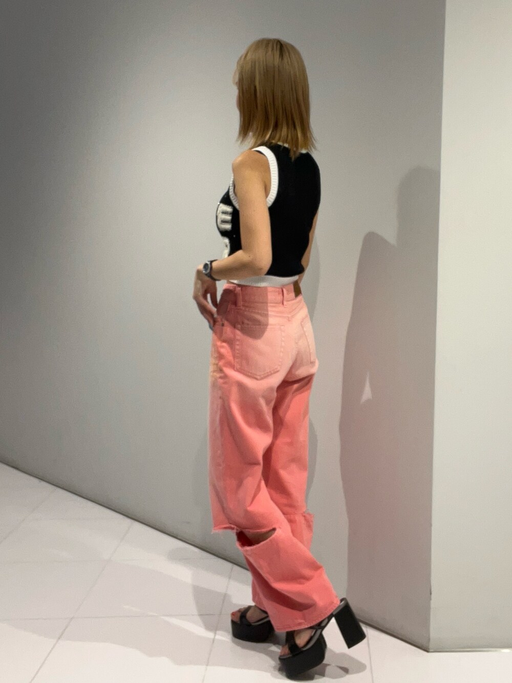 ブラック系のタンクトップ、ピンク系のデニムパンツ、ブラック系のサンダルを着用したレディースの夏コーディネートの5枚目の写真